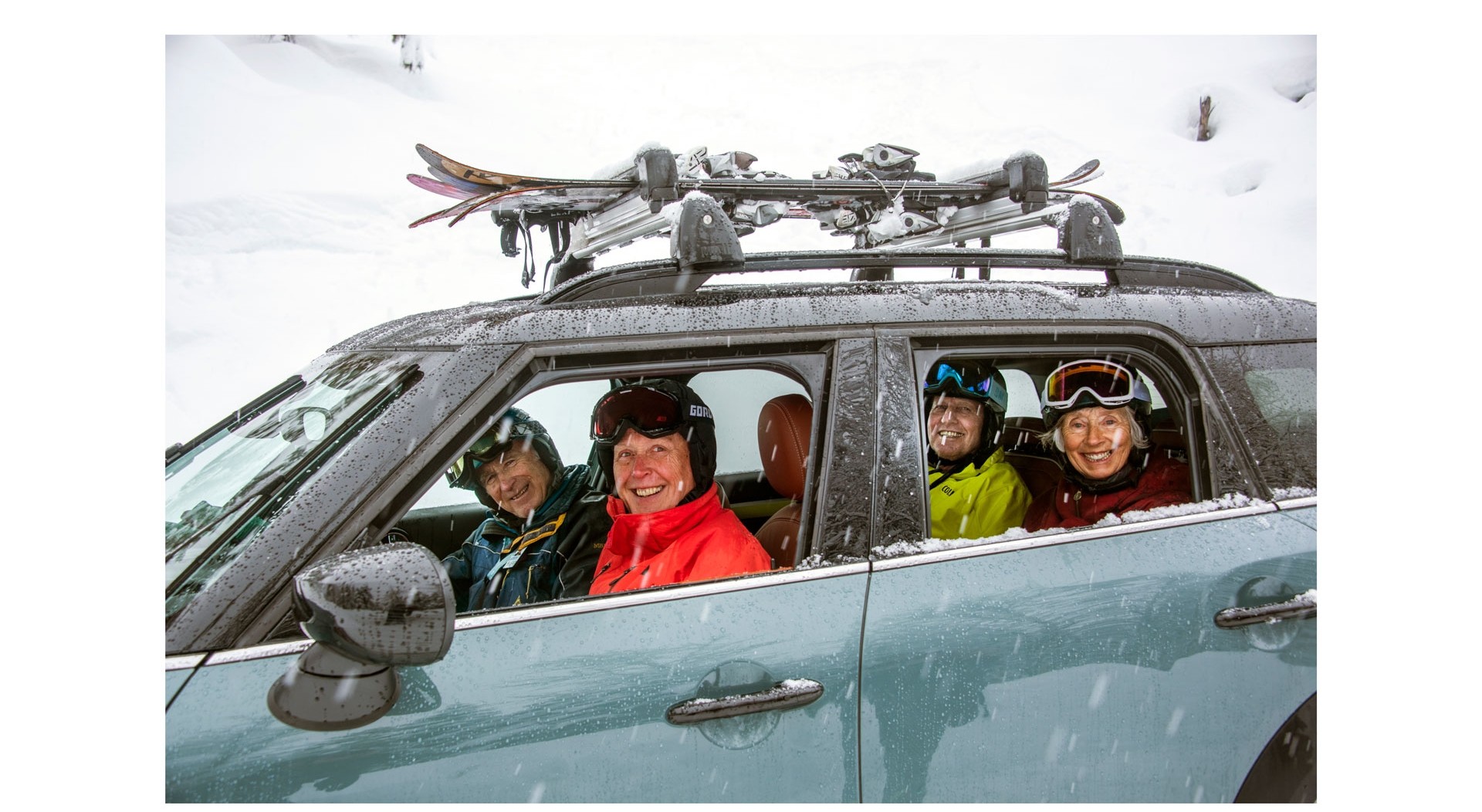 Equipa de Esqui “Silver Sliders” Imagem do MINI John Cooper Works Countryman ALL4, numa paisagem de neve com a equipa de esqui “Silver Sliders” a sorrir pela janela do carro.